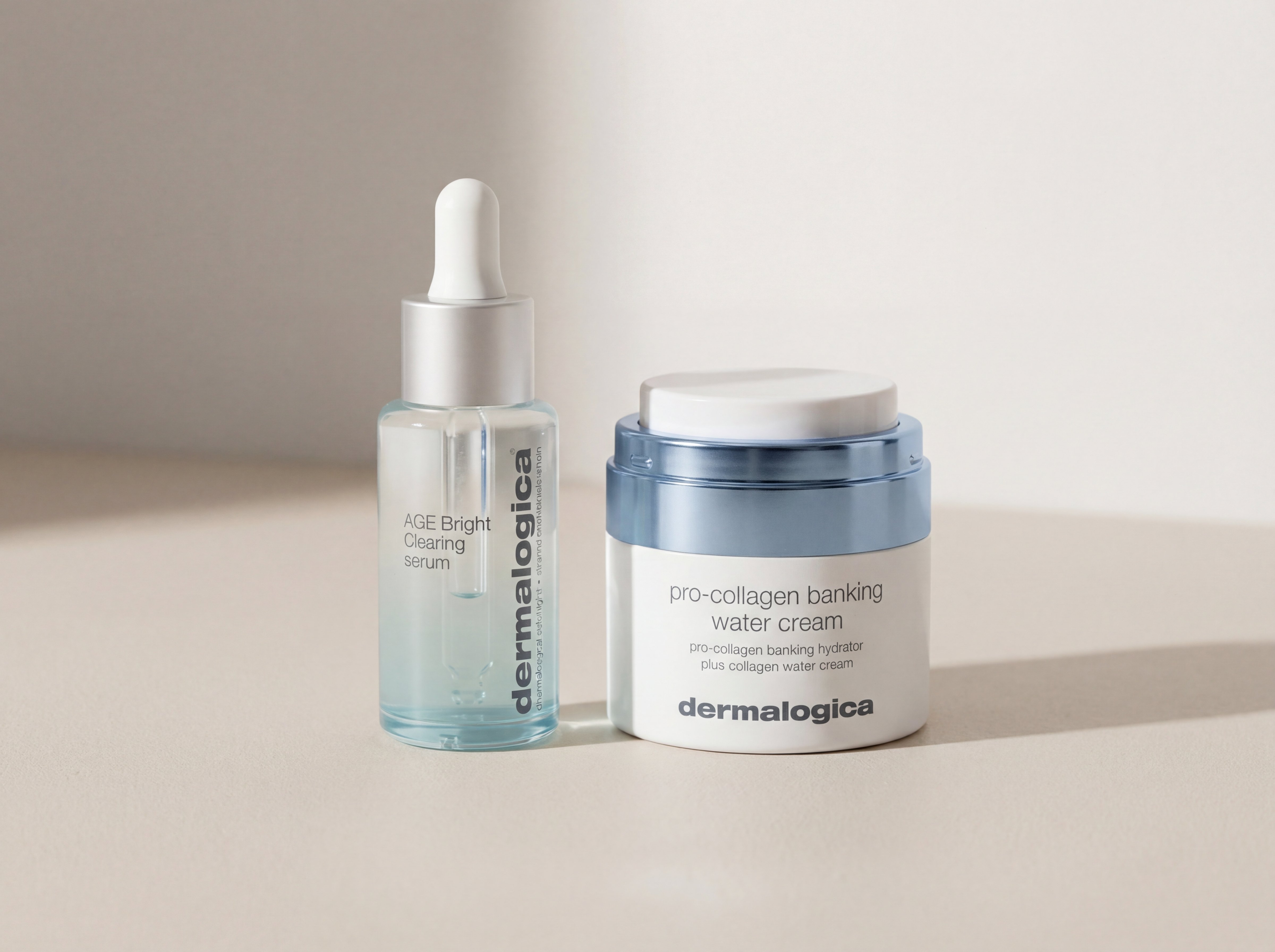 Dermalogica AGE Bright Clearing Serum and Pro-Collagen Banking Water Cream positioned together on minimal surface with soft natural lighting