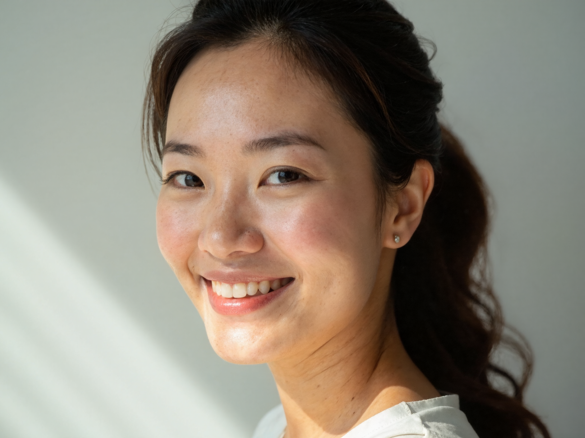 Woman in her early 40s with healthy hydrated skin showing natural radiance and plump texture in soft natural lighting