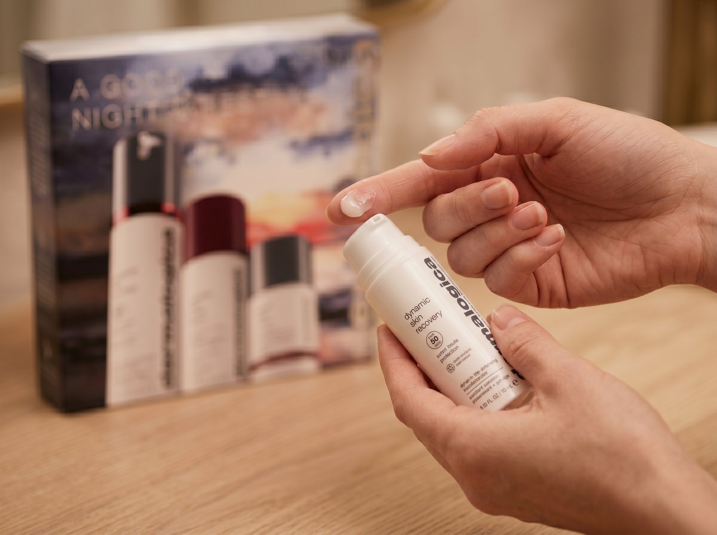 Close-up of a Pacific Islander Australian woman's hands applying a small amount of Dermalogica Multivitamin Power Recovery Masque, showing the rich cream texture