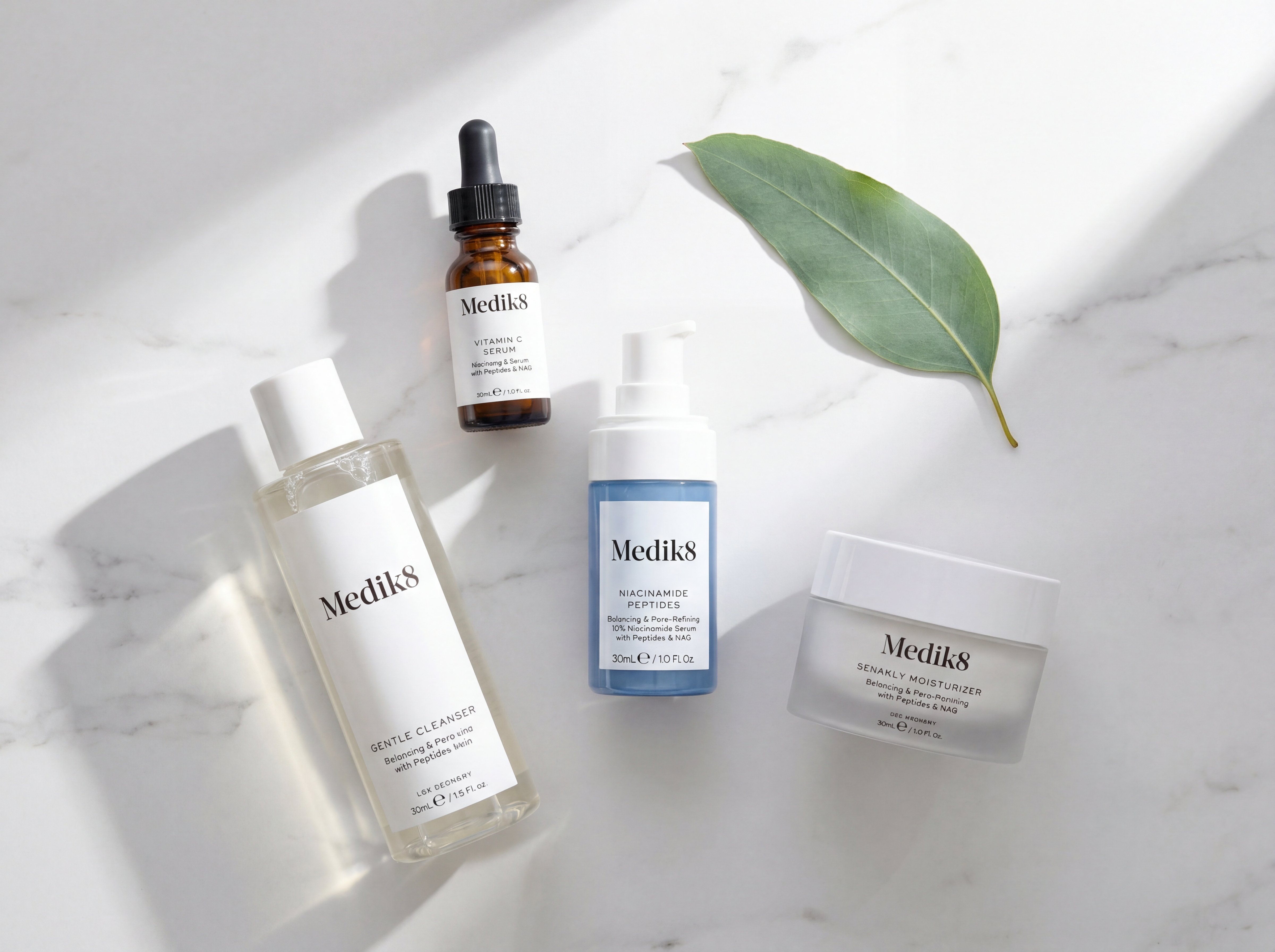 Morning skincare routine flat lay showing Medik8 Niacinamide Peptides positioned between cleanser and moisturiser on marble surface