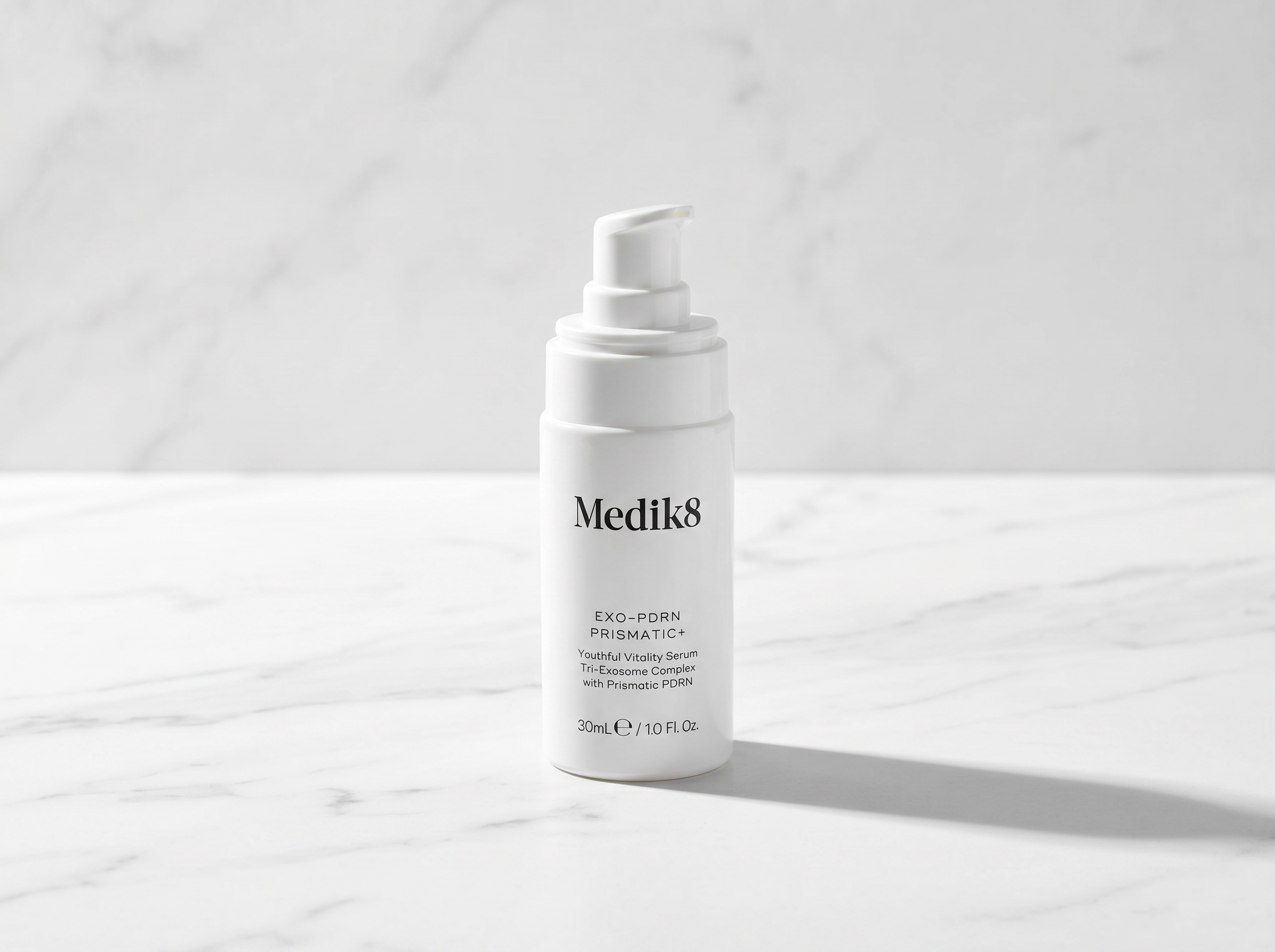 Single skincare serum bottle on white marble surface with soft directional lighting in a premium editorial product photography style