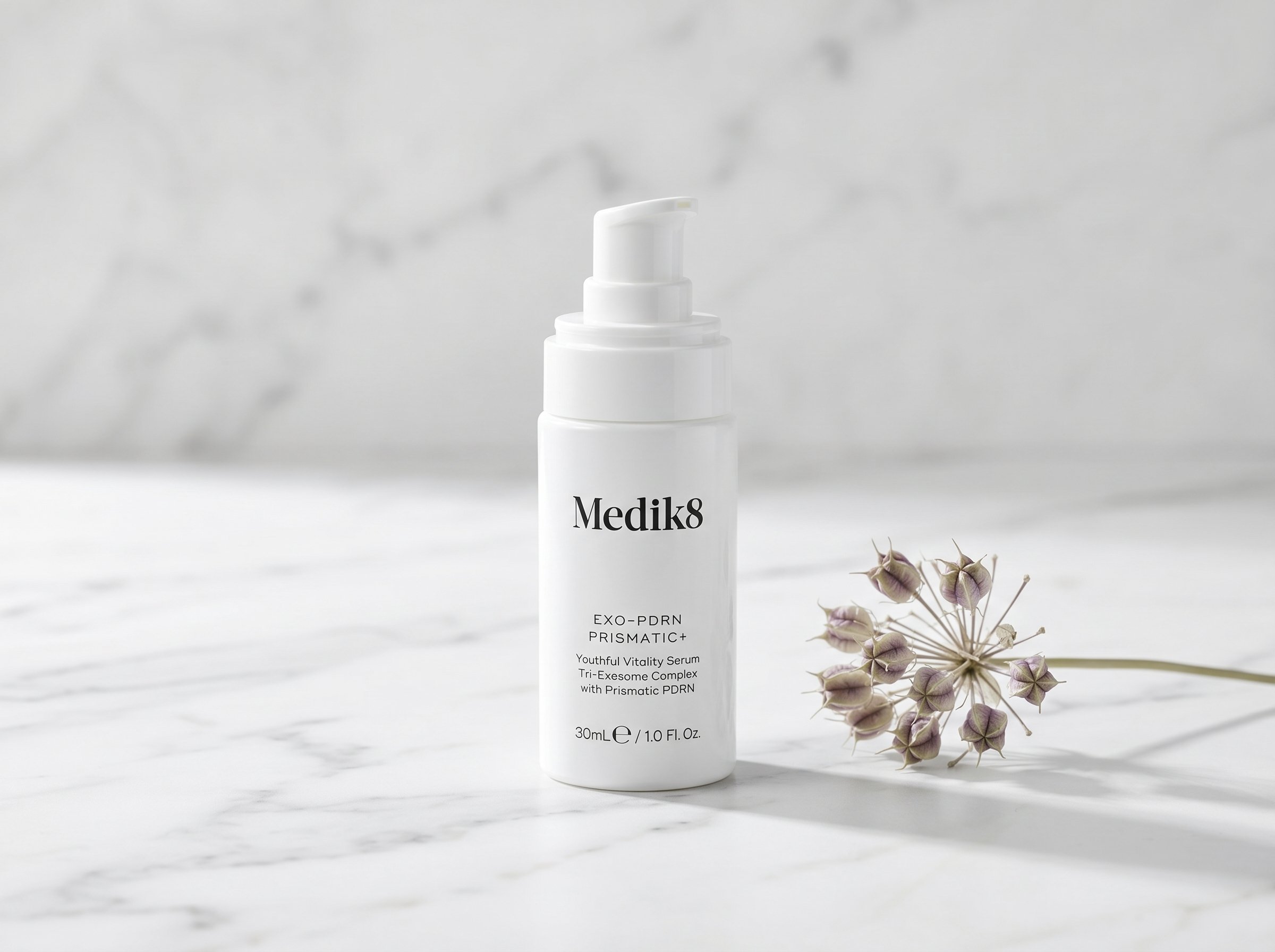 Medik8 Exo-PDRN Prismatic+ serum bottle on white marble surface with soft studio lighting and minimal botanical styling