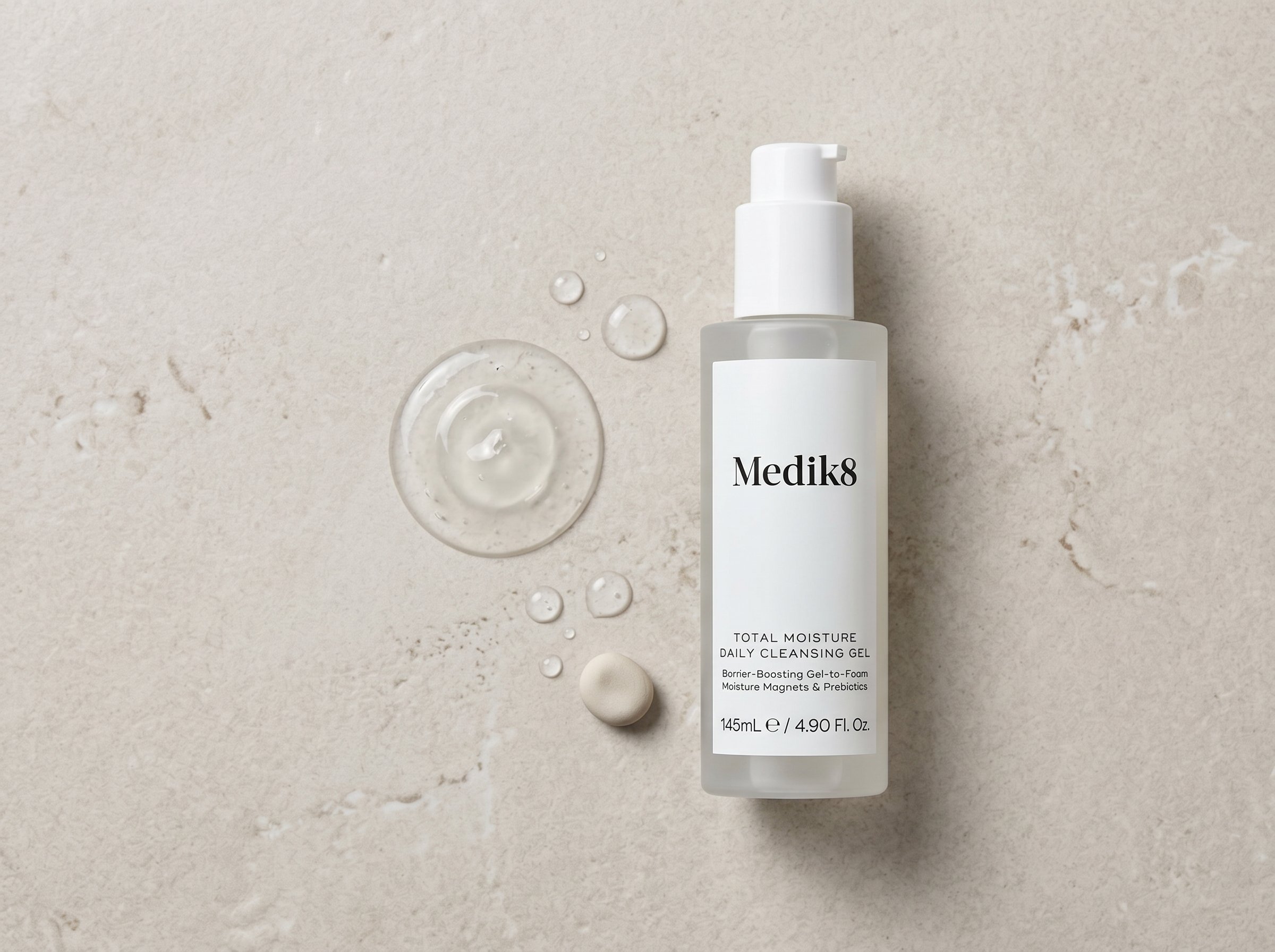 Medik8 Total Moisture Daily Cleansing Gel on a stone surface with gel texture dispensed beside it